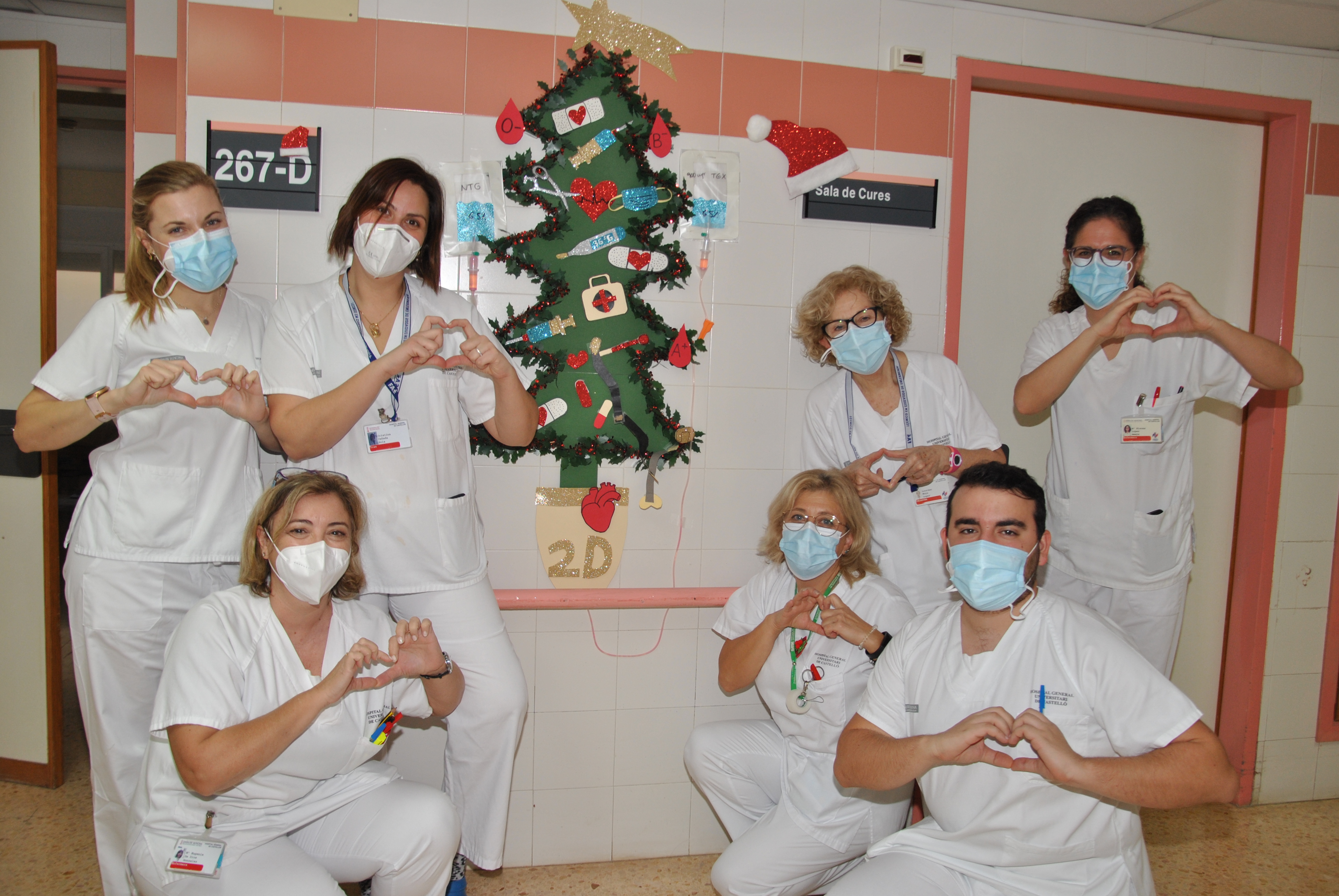 Un grupo de profesionales sanitarios frente a un arbol de navidad