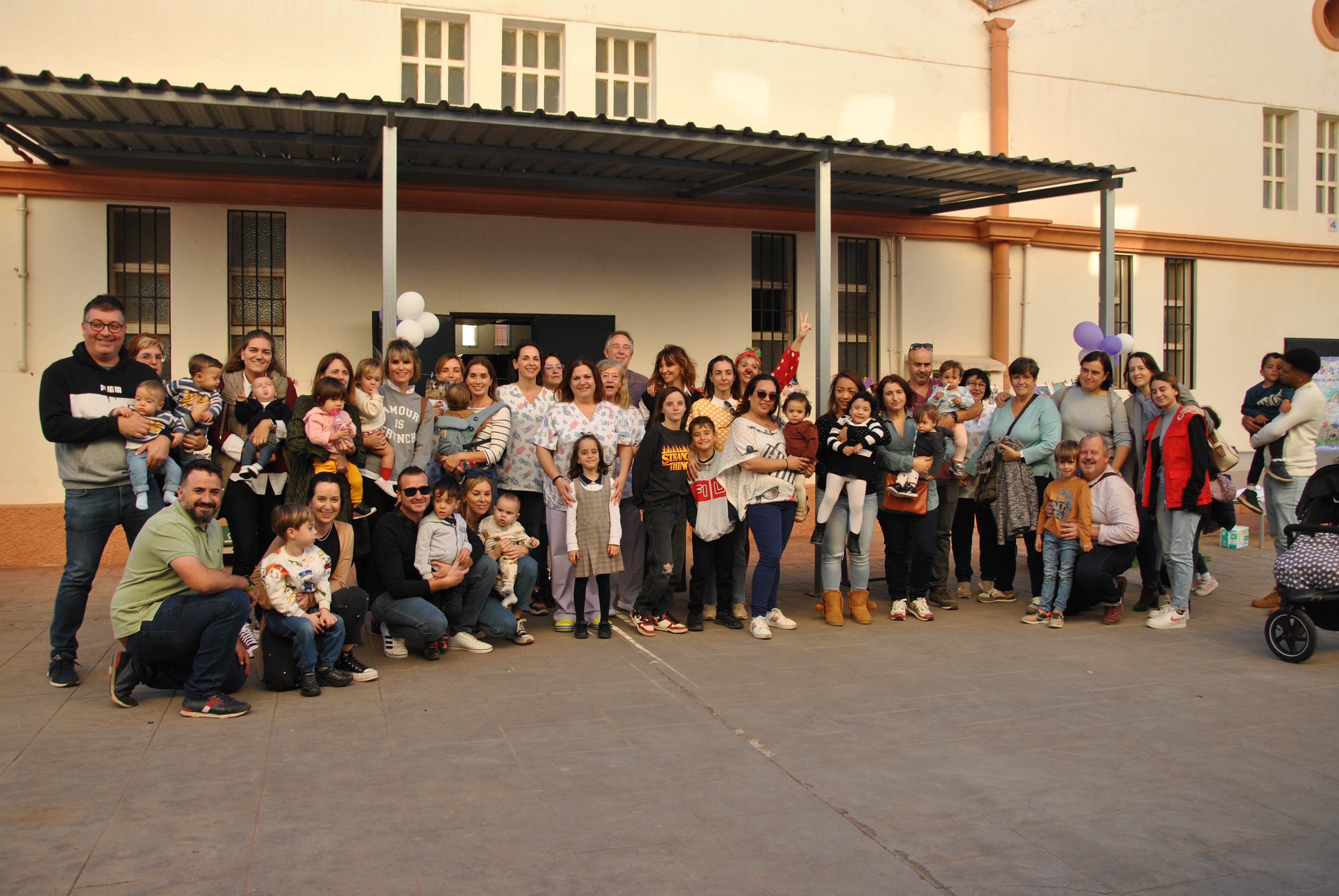 grupo de familias con menores que nacieron con prematuridad junto a personal sanitario en el patio del Hospital general de castellón