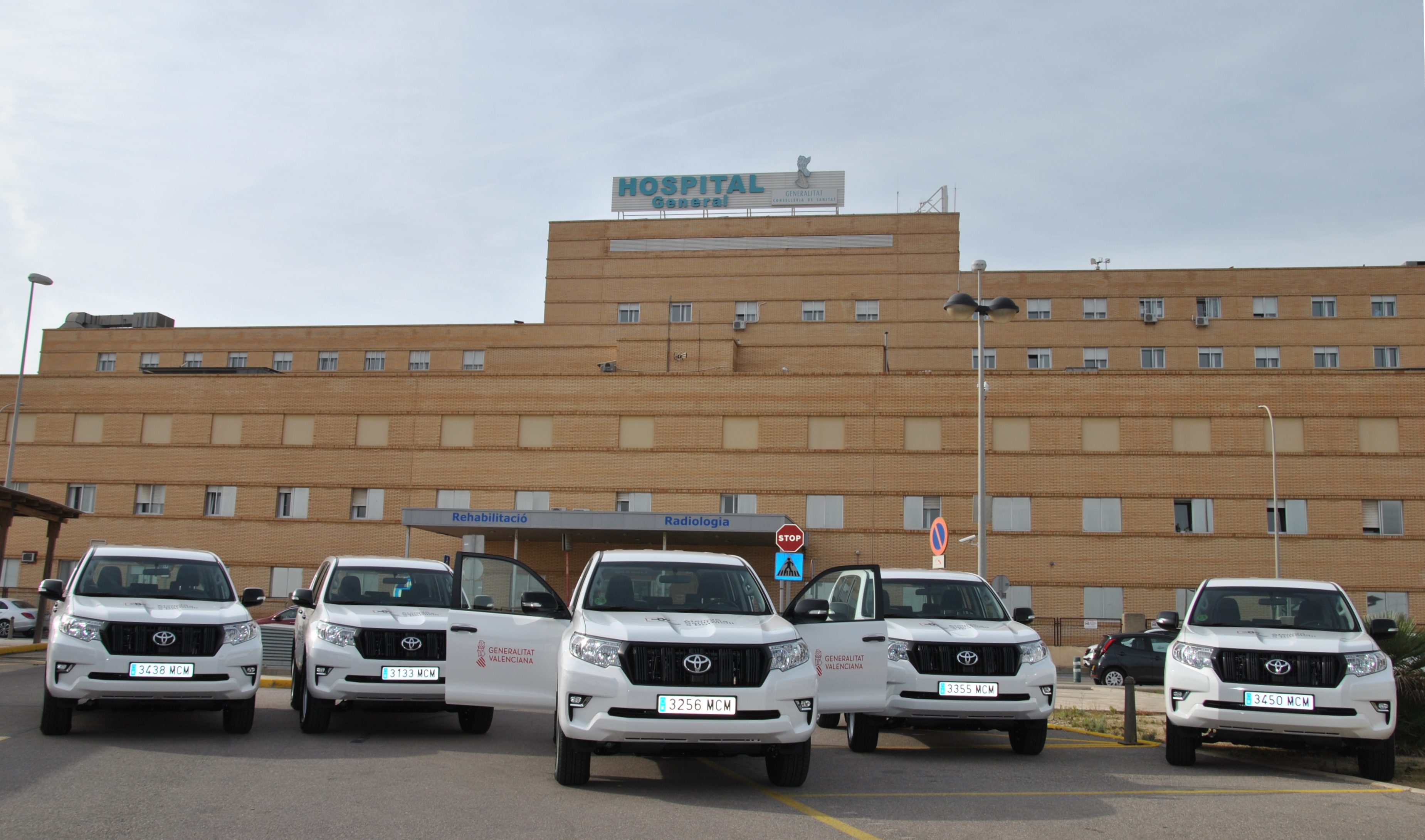 9 coches todoterreno blancos estacionados frente a la fachada del Hospital General de Castelló